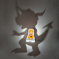 Agumon Digimon-inspired shadow lamp casting a gigantic dinosaur monster silhouette on the wall around its glowing orange character panel