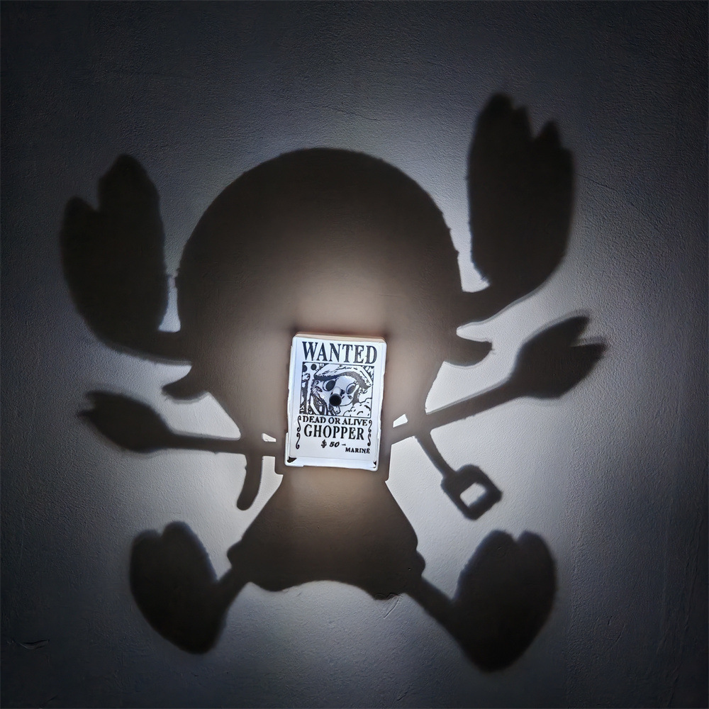 Chopper-inspired shadow projection lamp casting a large silhouette with antlers and raised paws around a WANTED Chopper poster on a wall