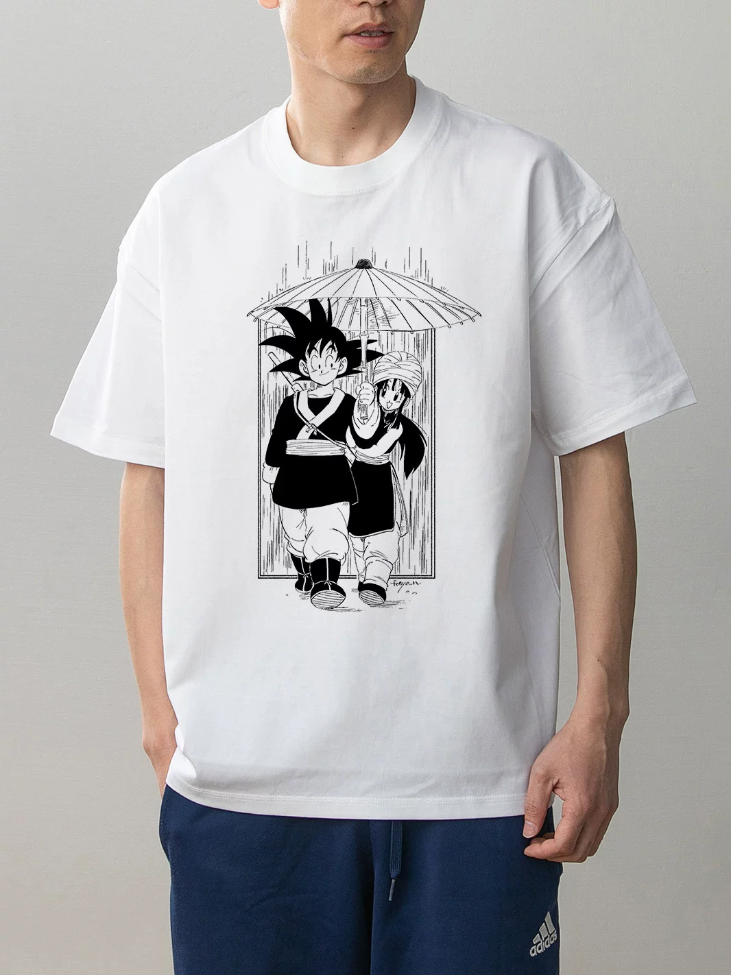 Dragon Ball Goku and Chi-Chi white cotton anime T-shirt on model front with monochrome umbrella manga illustration