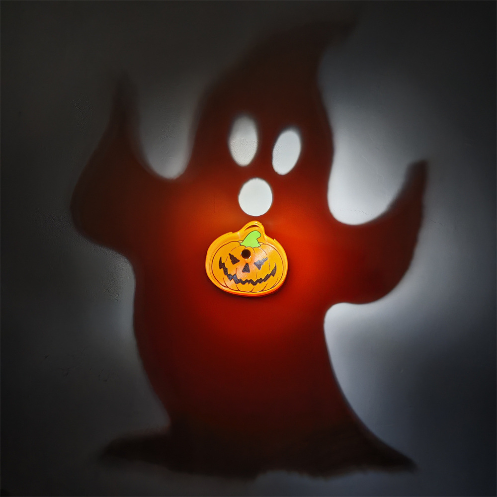 Halloween Ghost and Jack-o'-Lantern Shadow Lamp projecting giant spooky ghost onto wall with orange pumpkin centerpiece