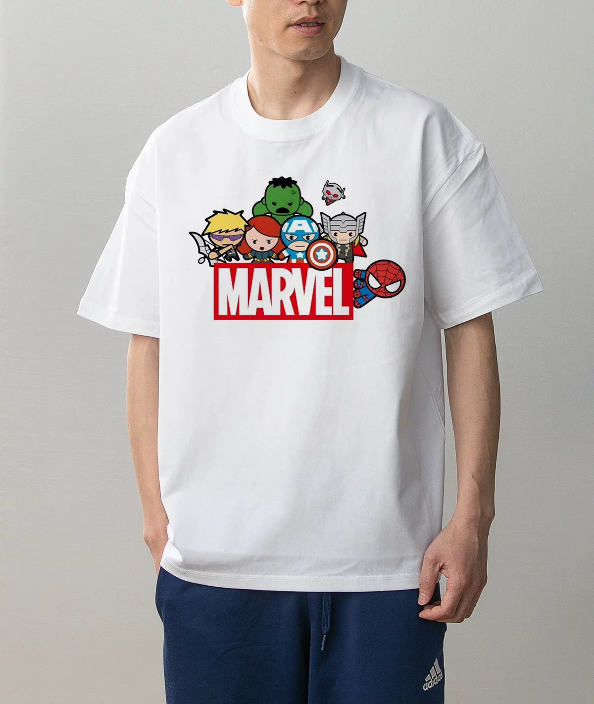 Model wearing Marvel Avengers chibi graphic white cotton T-shirt, front view showing cartoon Captain America Thor Hulk and Spider-Man