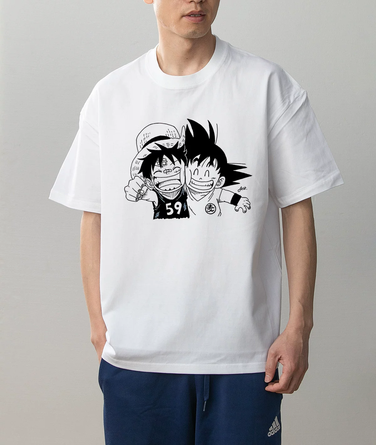 Model wearing Luffy and Kid Goku white cotton graphic T-shirt, black-and-white One Piece and Dragon Ball characters
