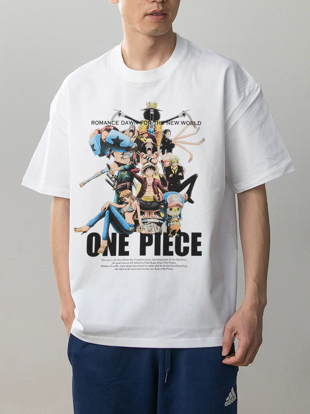 Model wearing a white One Piece Straw Hat crew graphic T-shirt with Luffy, Zoro, Nami, Sanji and Chopper artwork on the front