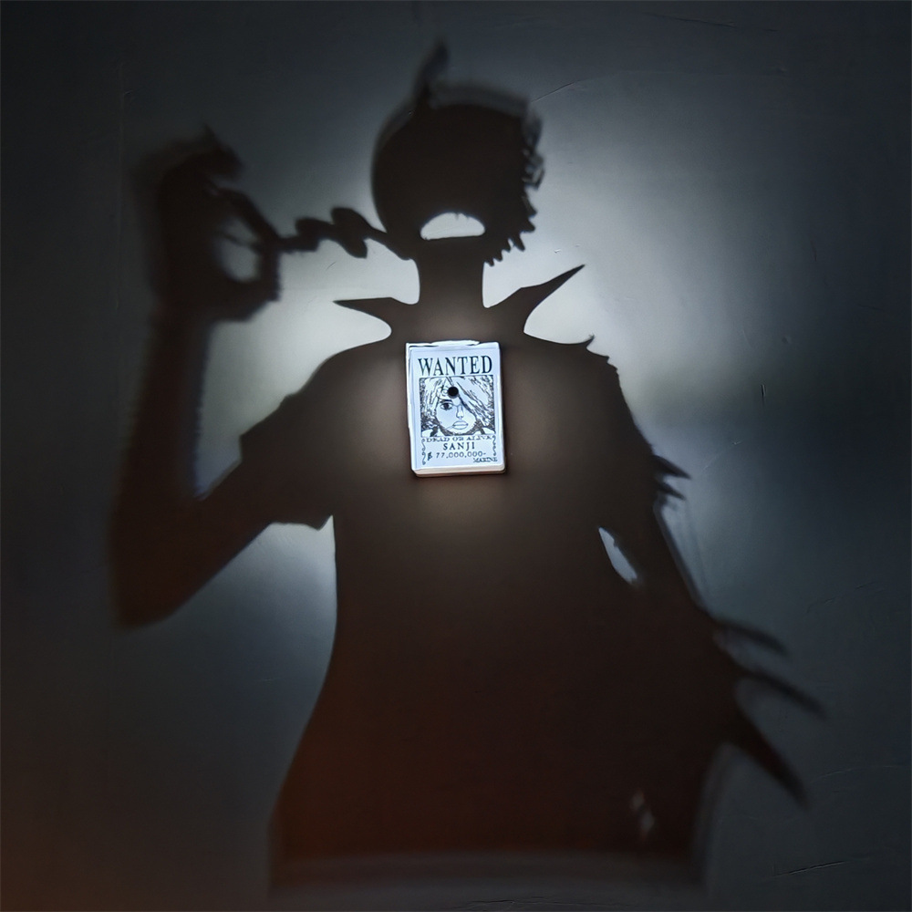 Sanji-inspired shadow projection lamp illuminating a WANTED Sanji bounty poster and casting a large anime character silhouette on a wall
