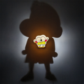 Shin-chan-inspired character shadow lamp casting a large cute cartoon child silhouette on wall with brightly lit central artwork