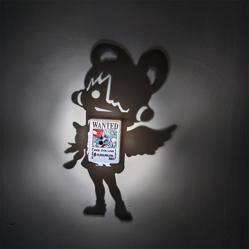 Uta-inspired One Piece shadow projection lamp casting a large anime singer silhouette on a wall around a colorful Red Uta Live WANTED poster